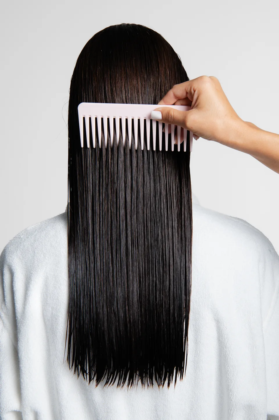 Woman combing long straight black hair, Avora Beauty social content