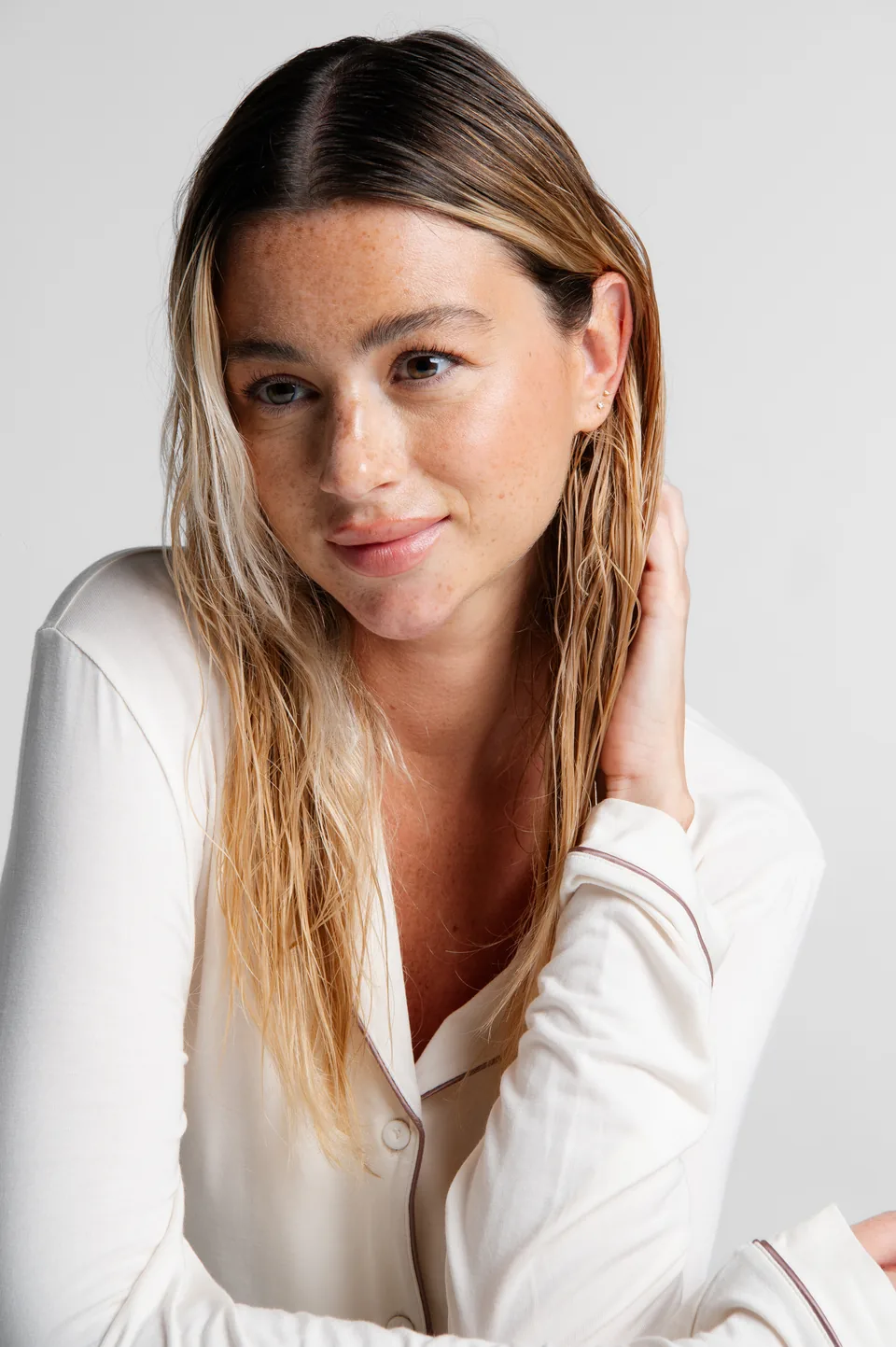 Blonde woman in a white blouse smiling, Avora Beauty photoshoot