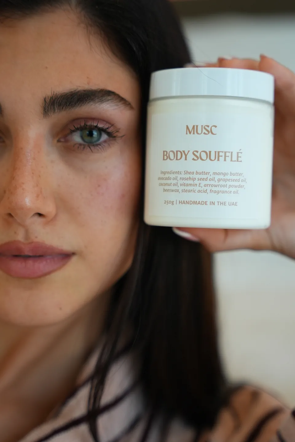 Woman holding a MUSC body soufflé jar