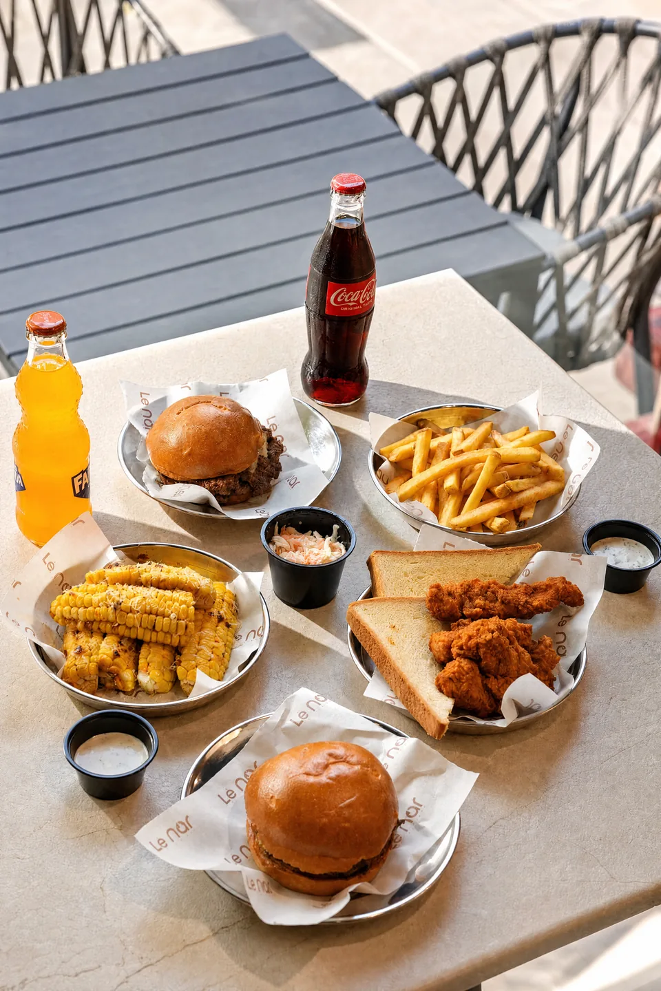 Spread of Lenar burgers, fries, chicken and drinks on a table