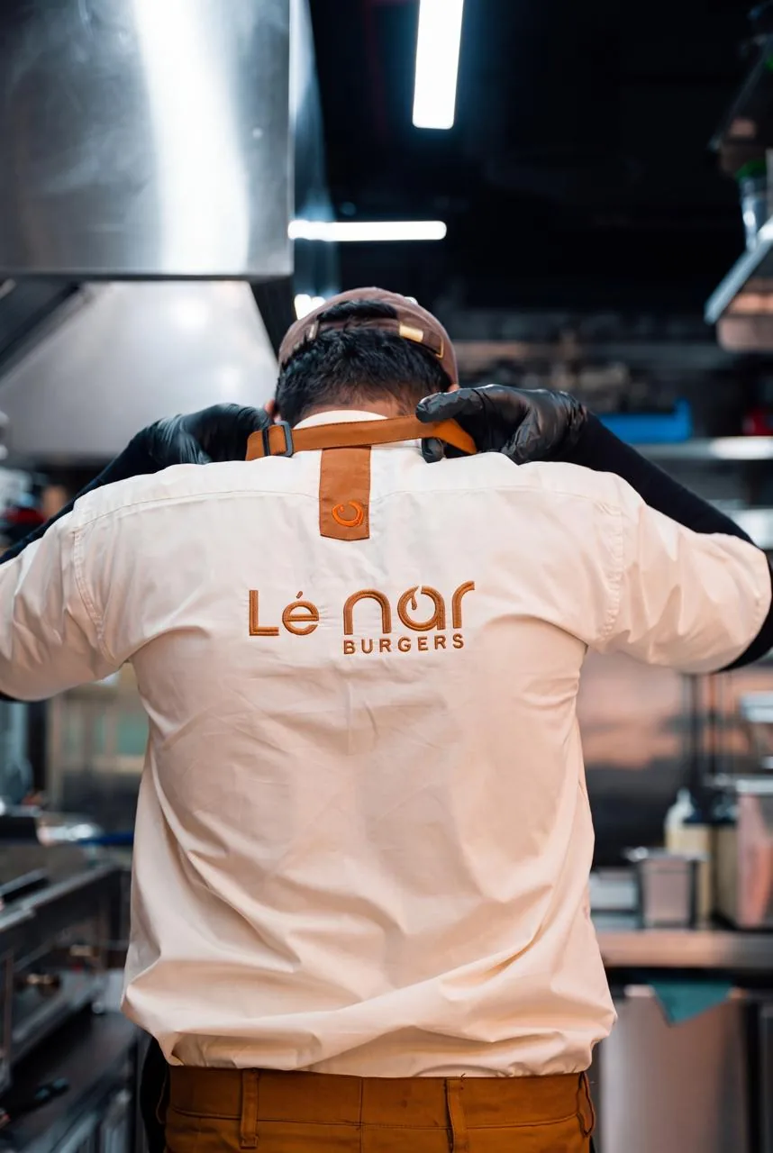 Lenar team member in a branded shirt working in the kitchen
