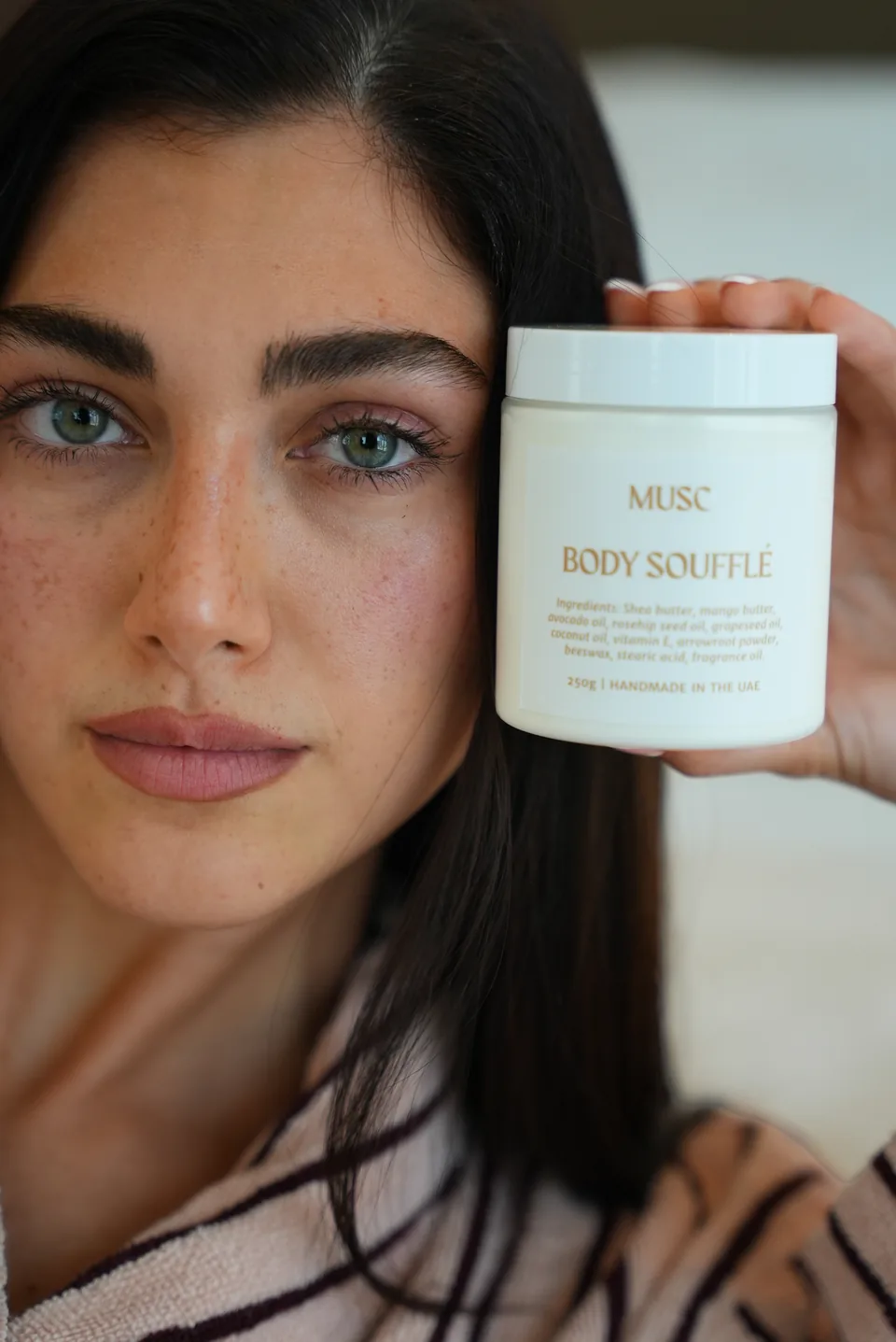 Woman holding a Musc body soufflé jar